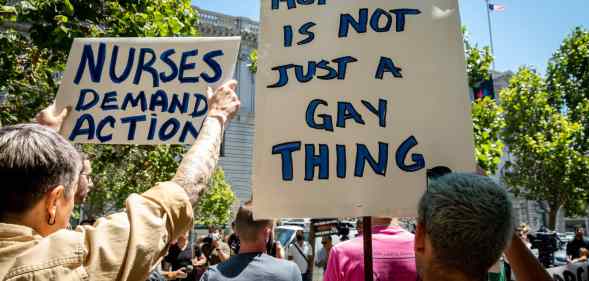 A person holds a sign reading: 'Monkeypox is not just a gay thing'