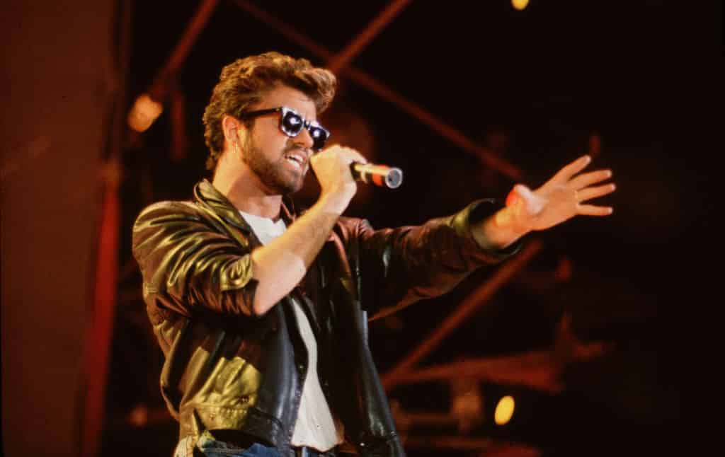 George Michael (1963 - 2016), of the group Wham, performs at Live Aid.