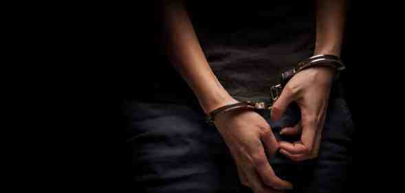 A teenagers hands in handcuffs