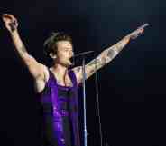 Harry Styles performs on the Main Stage at War Memorial Park in a purple sequinned dress