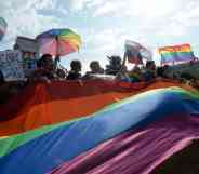 Activists wave rainbow flags during the gay pride rally in Saint Petersburg, Russia. The poeple hold up signs protesting against 'gay propaganda' laws and demanding change for the LGBTQ+ community