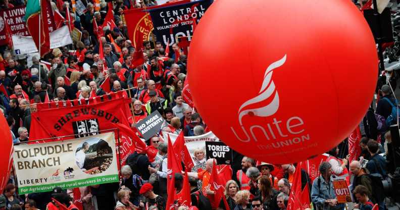 Protesters march with placards and trades union banners as part of a Trade Union Congress (TUC) demo