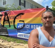 Justice Horn stands in front of his defaced banner