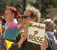 A person holds up a sign that reads 'Affirmation ≠ abuse' in protest of Texas officials investigating the families of trans youth for 'child abuse'