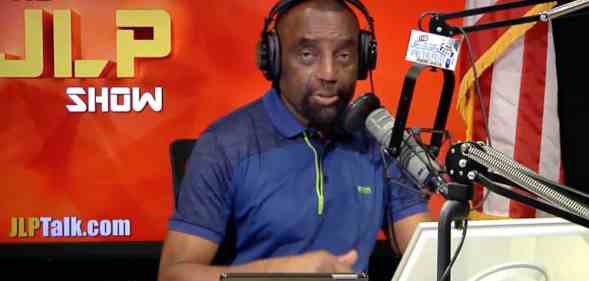 esse Lee Peterson wears a blue short-sleeved shirt as he speaks into a microphone and wears black headphones with two tablets placed in front of him