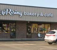 The image shows a business front with the words 'UpRising Bakery and Cafe' written in white. A white car is parked outside in the parking lot