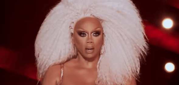 RuPaul with big blonde hair, looking shocked