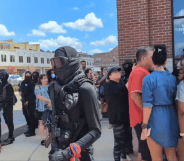 A group of armed counter-protestors stand around the Anderson Distillery and Grill.