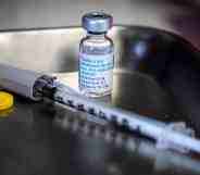 A bottle of monkeypox vaccine sits next to a needle on a tray