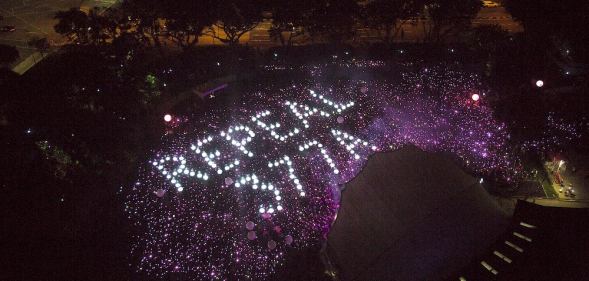 Attendees form the words 'Repeal 377A' in lights at Singapore's Pink Dot event, 2019