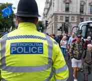 A Met Police officer looks towards people crossing the road