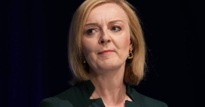 Liz Truss wears a dark green top as she stares somewhere off camera