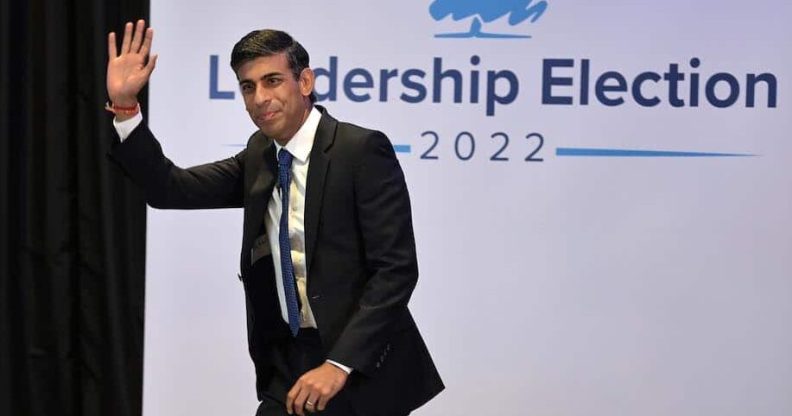 In this photograph, Rishi Sunak waves as he walks across the stage the the Conservative leadership hustings in Perth, Scotland