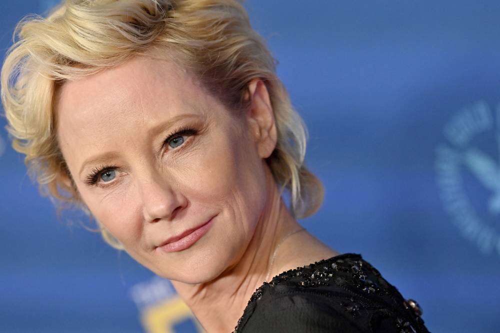 Anne Heche looks over her shoulder at the camera while wearing a black-coloured outfit