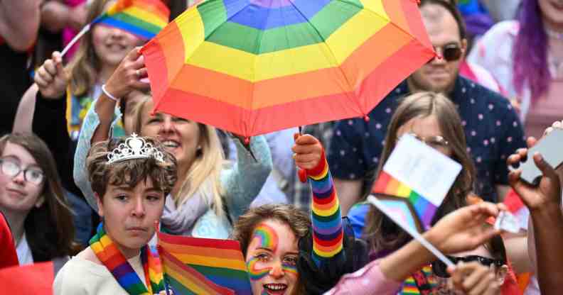 A woman holding a rainbow umbrella