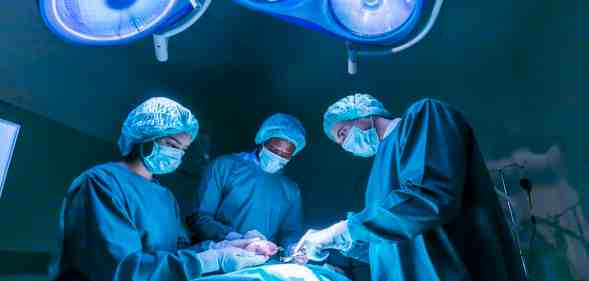 Team of surgeon doctors are performing heart surgery operation for patient