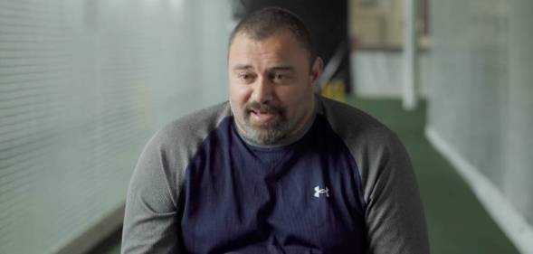 Former New Zealand cricketer Heath Davis wears a dark blue shirt with grey sleeves as he sits down for an interview