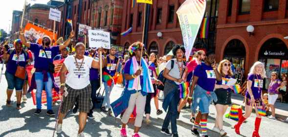 A scene from 2019 Manchester Pride event showing people marching on the streets