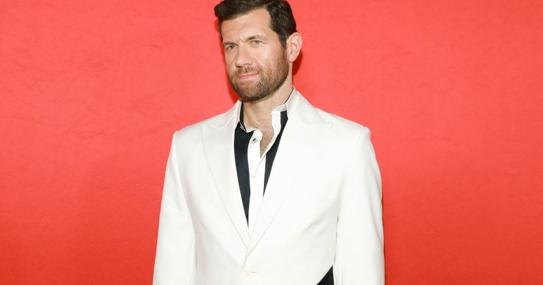 Promotional still of comedian Billy Eichner wearing a black shirt and white suit jacket.