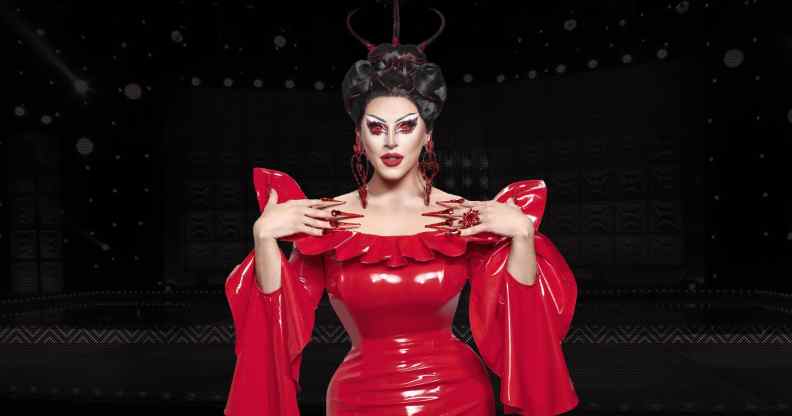 Drag Race UK star Cherry Valentine wearing a red dress against a black background in an edited image.