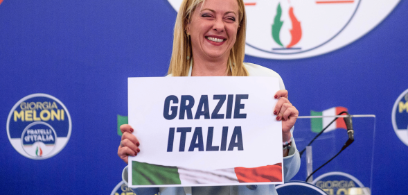 Giorgia Meloni holds up a sign reading 'Grazie Italia'