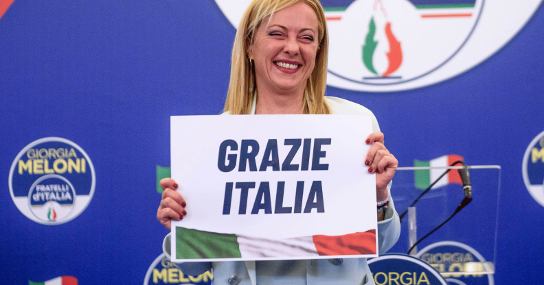 Giorgia Meloni holds up a sign reading 'Grazie Italia'