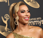 Shangela wears a gold dress as she stares somewhere off camera