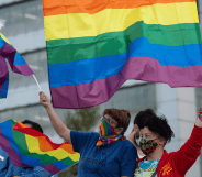 A crowd of people in Chile wave LGBTQ+ Pride flags