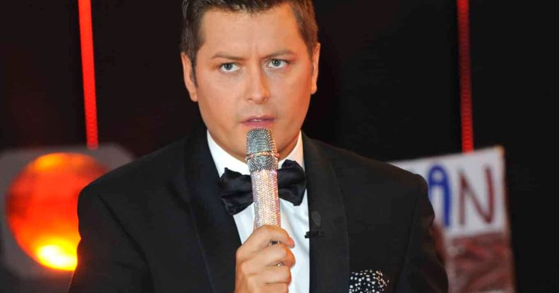 Brian Dowling holds a microphone