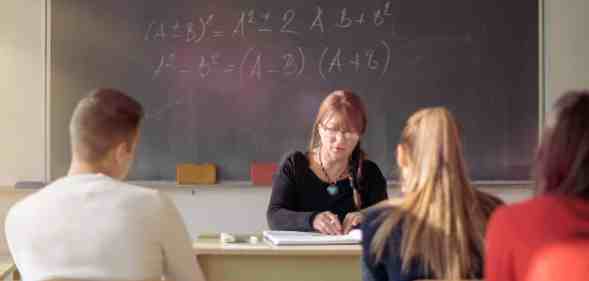 Teacher and students in high school classroom.