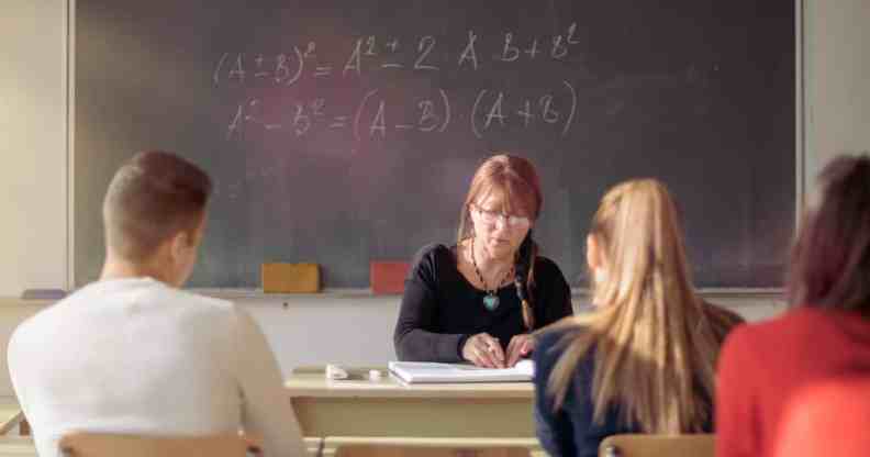 Teacher and students in high school classroom.