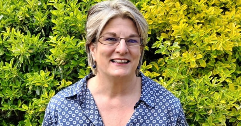 Jayne Ozanne smiling in front of some bushes