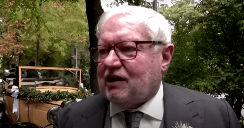 Gay former monk Anselm Bilgri wears a suit as he talks to someone off camera after his wedding