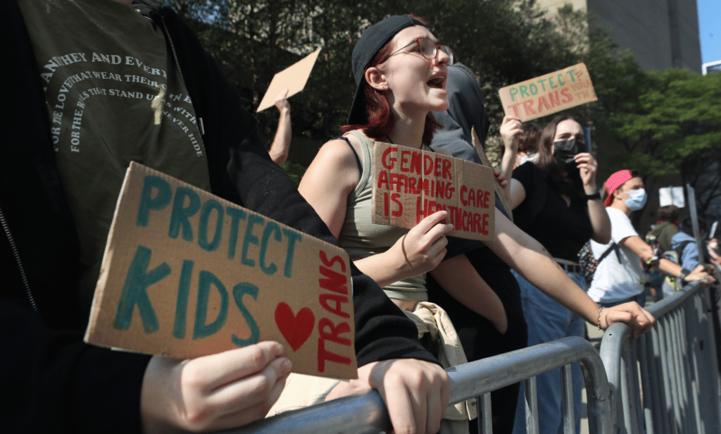 Several people gather outside to show their support for gender-affirming healthcare for trans youth in the US