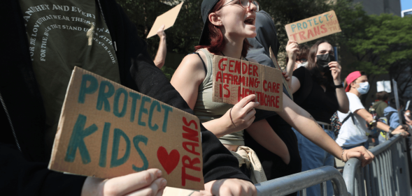 Several people gather outside to show their support for gender-affirming healthcare for trans youth in the US