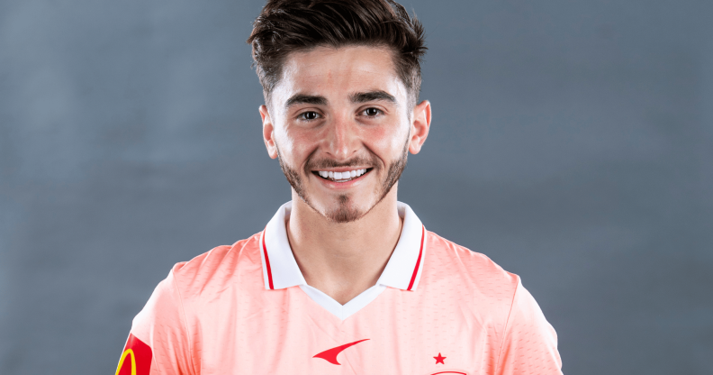 Josh Cavallo smiles as he wears a pink football uniform for the Australian team Adelaide United