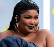 Lizzo wears a blue outfit as she poses for a photo at an event