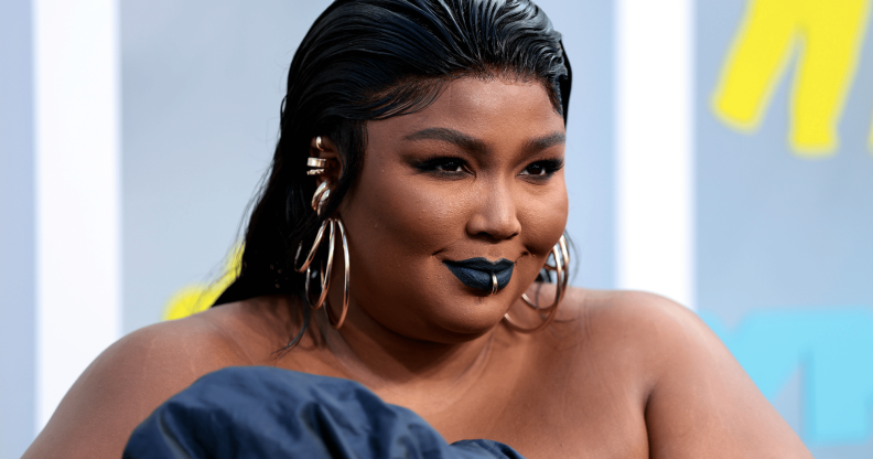 Lizzo wears a blue outfit as she poses for a photo at an event