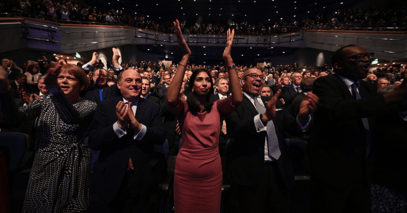 People stand and applaud during a speech at the Conservative Party conference