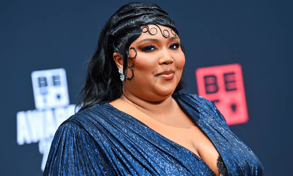 Lizzo wears a blue outfit as she poses for a photo at an event