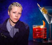 A photo of actor Emma D'Arcy sitting next to two drinks that are placed on a table