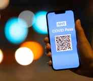 A woman holds an Apple iPhone showing a NHS Covid Pass on October 8, 2021.