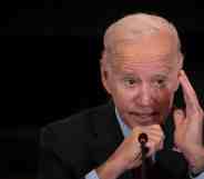 An image of US President Joe Biden speaking into a microphone