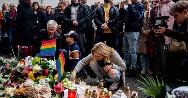 People attend the vigil in Slovakia, placing Pride flags and candles, following the shooting where two men were killed