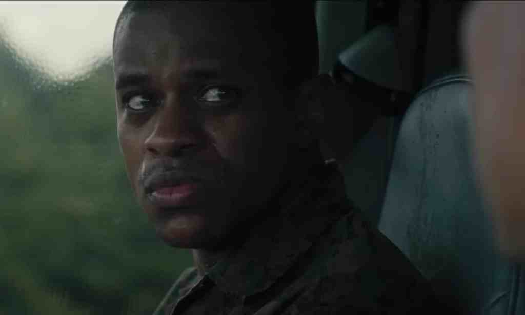 A still from the movie The Inspection shows actor Jeremy Pope sitting in front of a window and looking worried