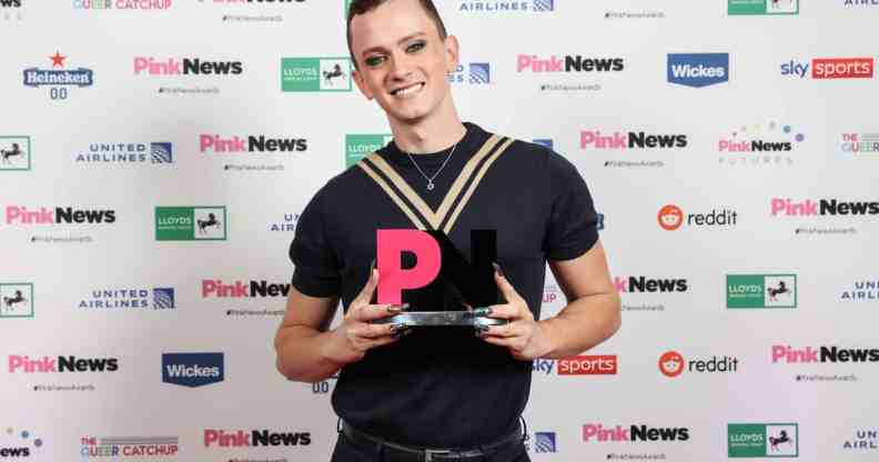 Matt Bernstein smiles with his award at the PinkNews Awards 2022 event. (PinkNews)