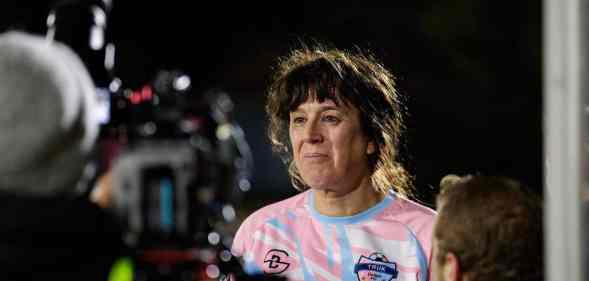 A photo of trans woman Paula Griffin in front of a camera after playing a match with her women's football team