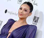 A photo of actor Shay Mitchell wearing a purple dress at a media event