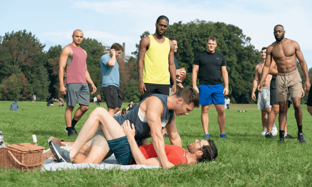 Billy and Luke wrestle on grass as others look on