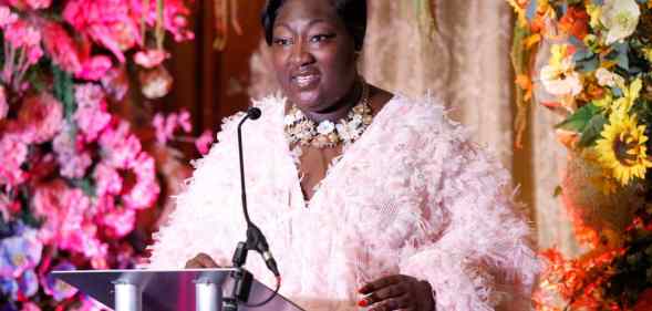 A photo of Phyll Opoku-Gyimah wearing a pink dress as she speaks at the Kaleidoscope Trust Gala dinner